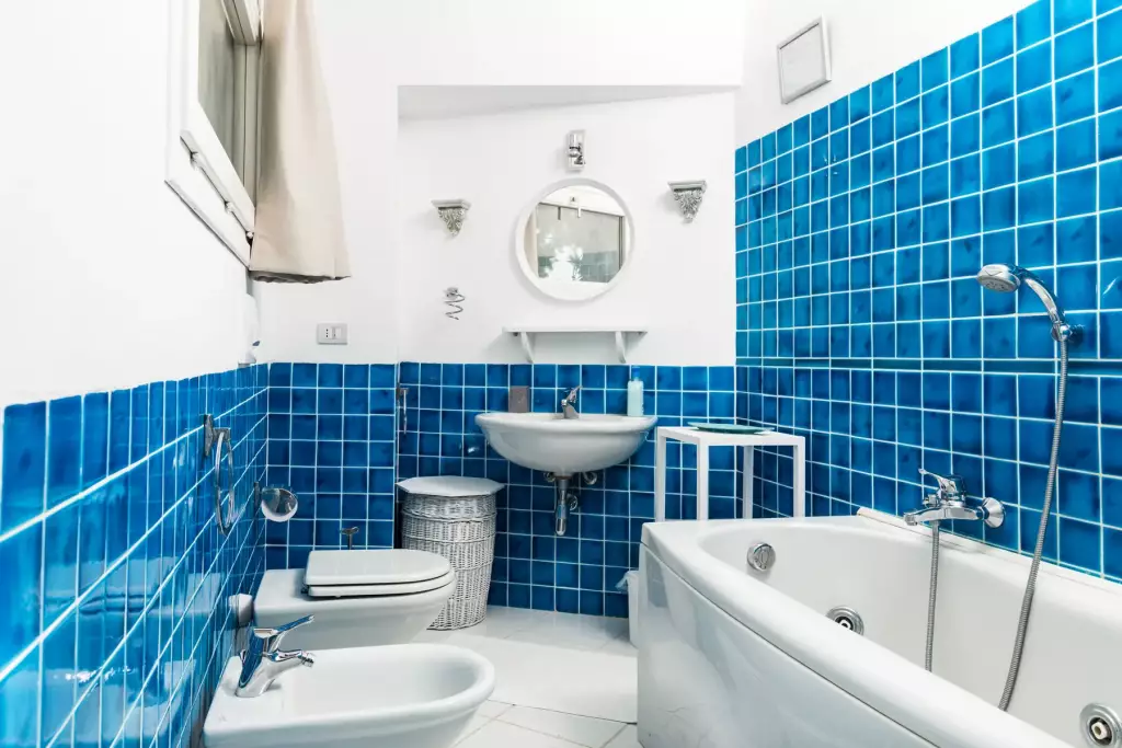 Bagno con piastrelle blu e vasca idromassaggio