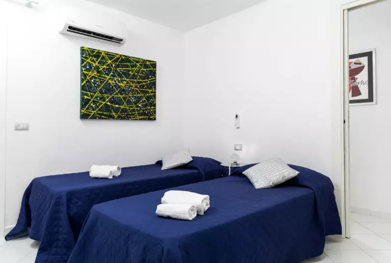 Camera con letti singoli e copriletto blu