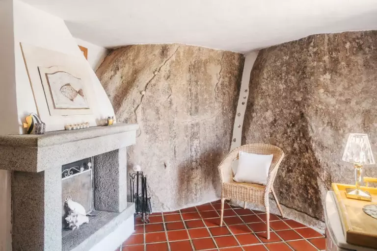 Interno di dependance con roccia viva e camino