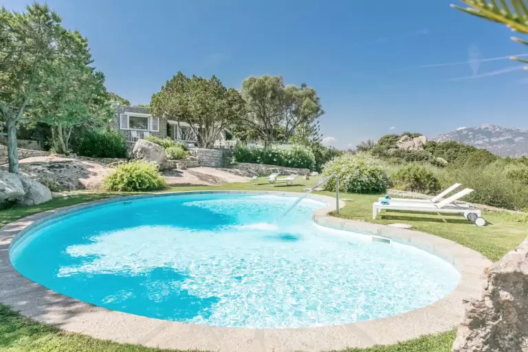 Piscina grande con lettini e prato