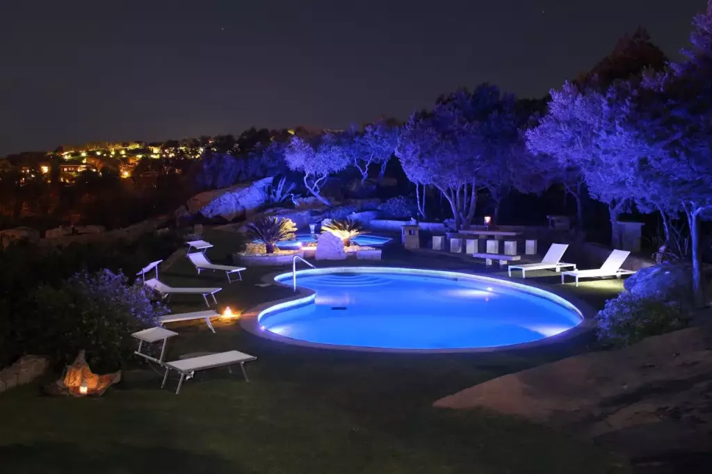 Piscina illuminata di notte tra le rocce