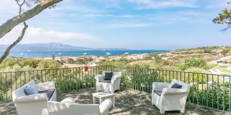 Terrazza fronte mare con tavolo e sedie bianche